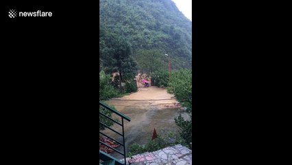 Moment men desperately try to stop floodwater from entering village