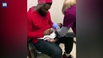 أب يحاول تهدئة طفله الرضيع أثناء فحص طبي بشكل يلامس القلب