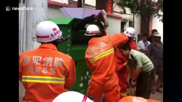 Firefighters free man stuck in recycling bin