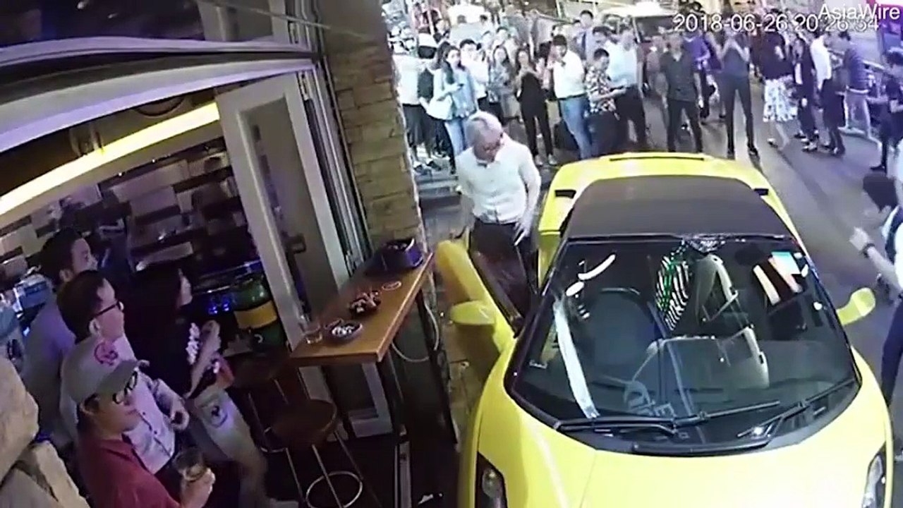 Moment Lamborghini rolls down busy street and smashes into bar