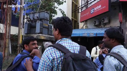 Indian men scale a billboard scaffold in political protest