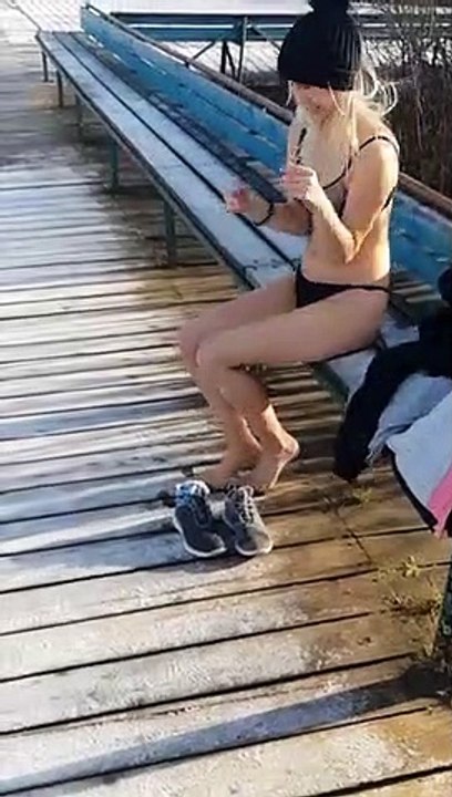 Une jeune femme saute dans un lac gelé