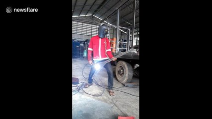 When you're supposed to be working... lad plays electric guitar with a welding gun