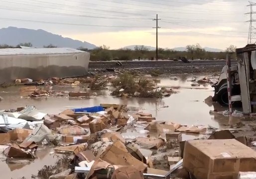 Packages Strewn Beside Flooded Track as Rain Causes Train Derailment in Arizona
