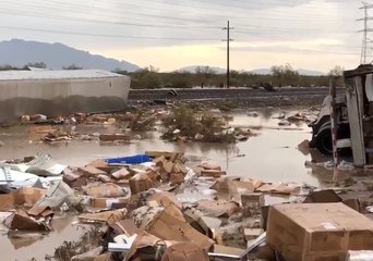 Packages Strewn Beside Flooded Track as Rain Causes Train Derailment in Arizona