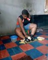Nigerian Lady With One Hand Peeling Potatoes With Her Legs