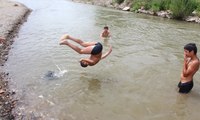 Tehlikeye aldırış etmeden nehirde yüzüyorlar