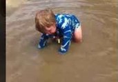 Happy Child Lives His Best Life by Splashing Around in Muddy Puddle