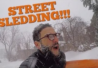 Guy on Sled Races Street Snowplow