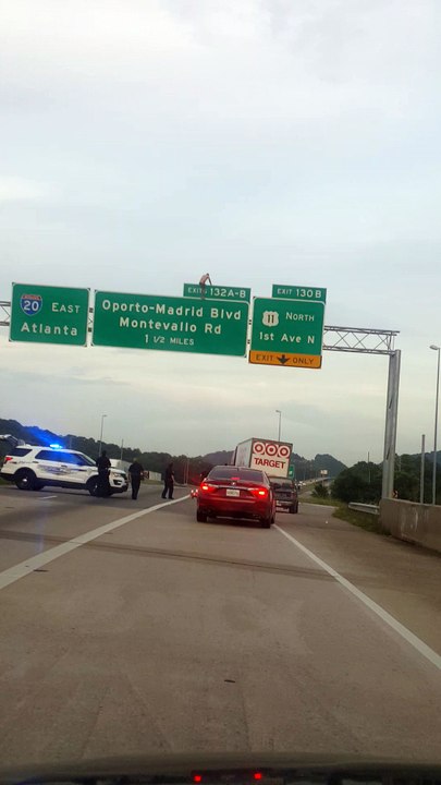 Man Sits on Interstate Sign