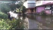 Indian club practices for boat race on flooded road in town