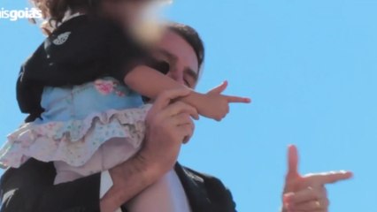 Bolsonaro ensina criança de colo a simular revólver com os dedos