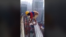 Des ouvriers travaillent sans sécurité en haut d'un gratte-ciel