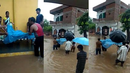 बाढ़ जैसे हालात के बीच चारपाई में लिटाकर अस्पताल पहुंचाई गई गर्भवती महिला, देखें VIDEO