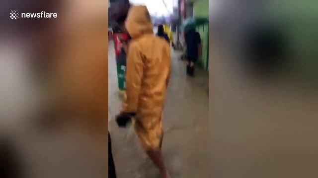 Mourners carry coffin through flooded street in the Philippines