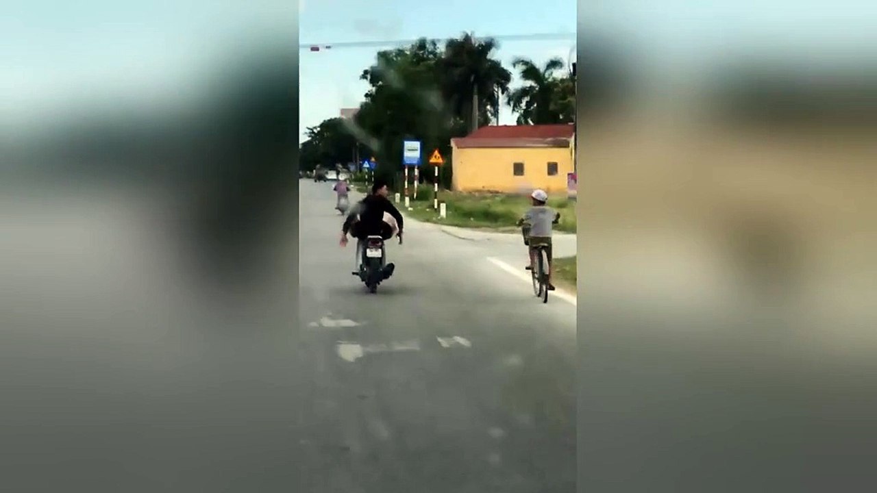Man puts life in danger by riding motorbike with feet down busy road