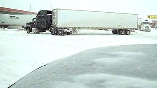 Big rig spinning out on snow trying to get to fuel pump.