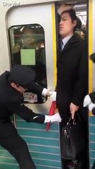 Stony-faced passenger squeezes onto Tokyo subway during rush hour