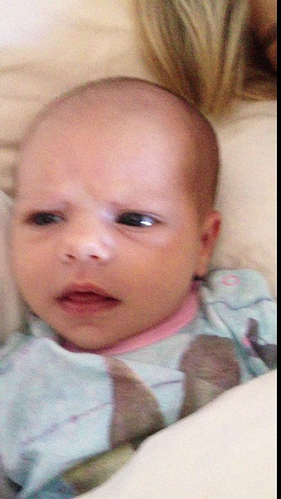 Six week old newborn girl smiling and trying to talk to her dad.