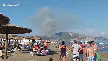 Wildfire burning in distance doesn’t ruin day for beachgoers on Greek island