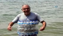 Yüzme bilmeyen engelli vatandaş, su şişelerinden can simidi yaparak serinledi
