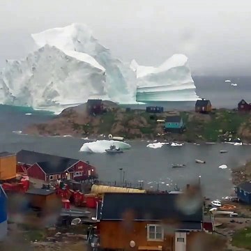 Groenlandia : enorme iceberg a la deriva enfrente de pueblo costero