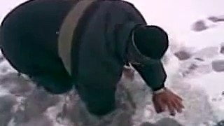 Russian man catches a big fish with bare hands from an ice hole