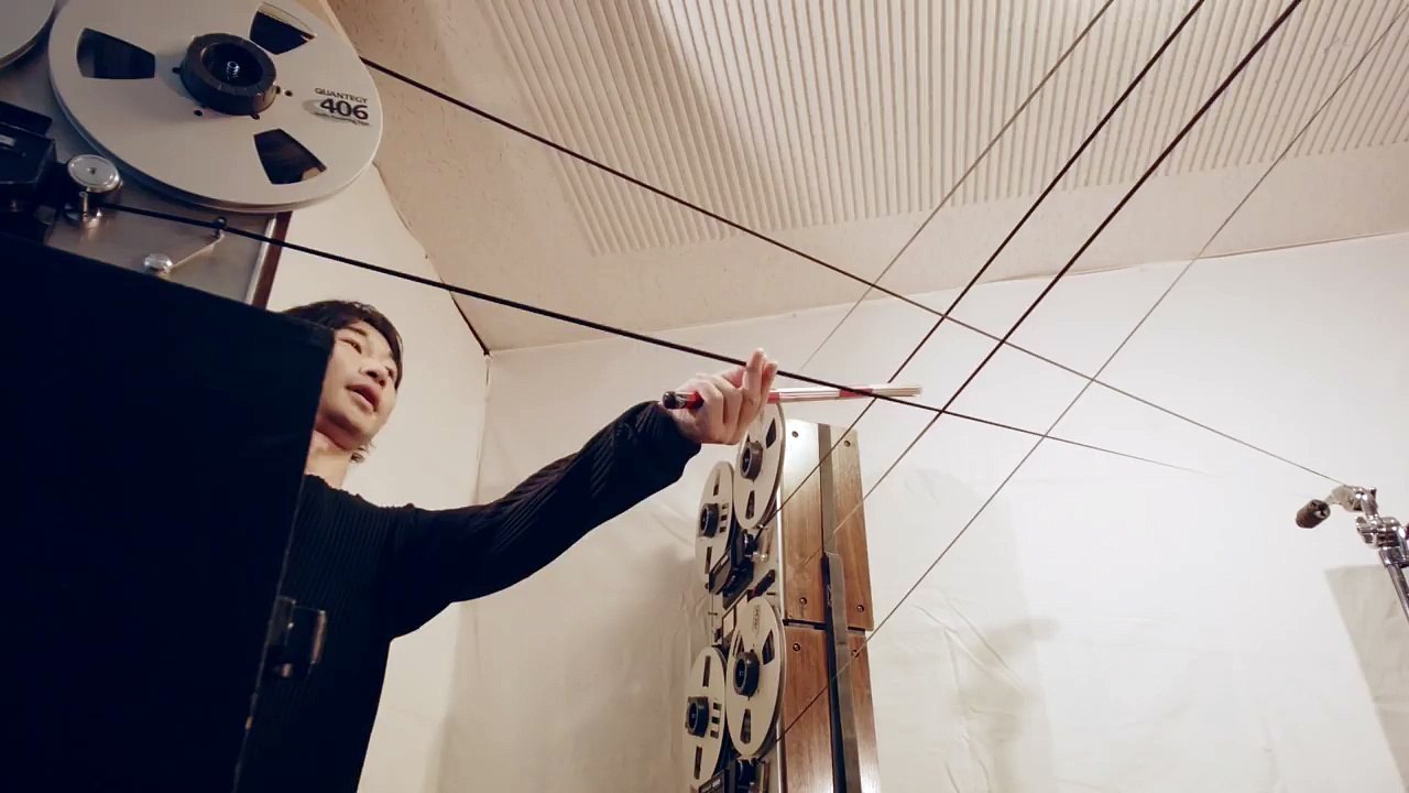 Il joue de la batterie sur des bandes audio tendues en l'air