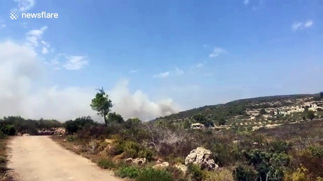 Helicopters race to pick up water to fight wildfires in Spain