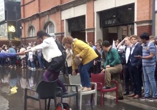 Londoners Cross Flooded Pavement Using Makeshift Chair Bridge