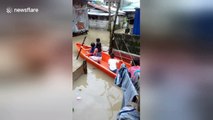 Children use boat to get around village during flooding in the Philippines