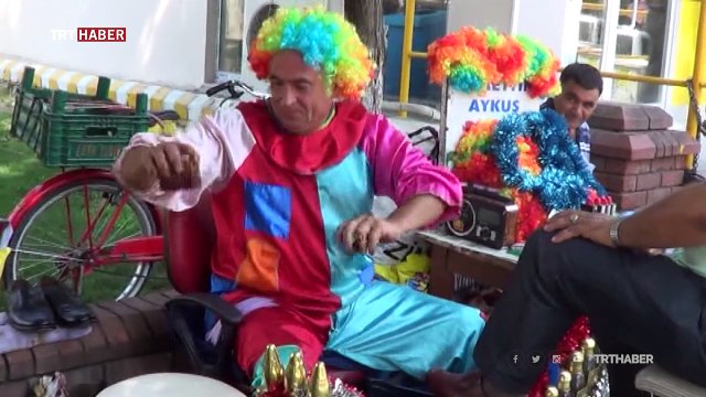 Palyaço kostümüyle hem ayakkabı boyuyor hem insanları eğlendiriyor