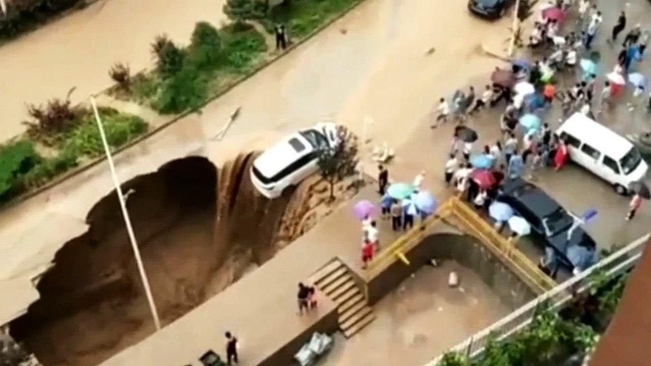 Samaritans team up to rescue a car from a huge sinkhole