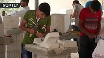 اللاجئون السوريون في الأردن يرممون تحفا أثرية دمرها 'داعش'