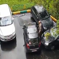 Un grand père pousse sa voiture pour sortir d’une place de parking