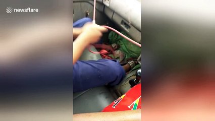 Hilarious moment men use rope to operate broken windscreen wipers in heavy rain