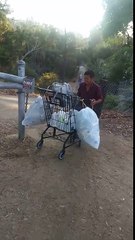 Un SDF collecte des canettes pour le recyclage rapidement