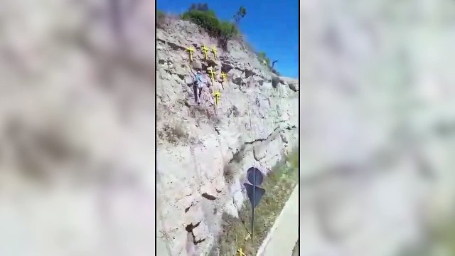 Un hombre escalando para quitar cruces amarillas