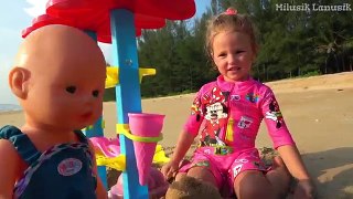 Kid and Dolls Pretend Play with colored Ice Cream Toys and cakes from sand on the Beach