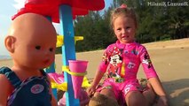 Kid and Dolls Pretend Play with colored Ice Cream Toys and cakes from sand on the Beach