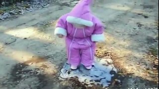 Little girl in pink snow suit experiences ice for first time