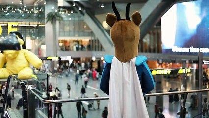 One mascot from the Oryx Kids Club, a trolley of gifts, Hamad International Airport, and travelling passengers. We surprised a few young travellers en route to