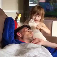daughter pokes dad eyes with a crayon as he sleeps