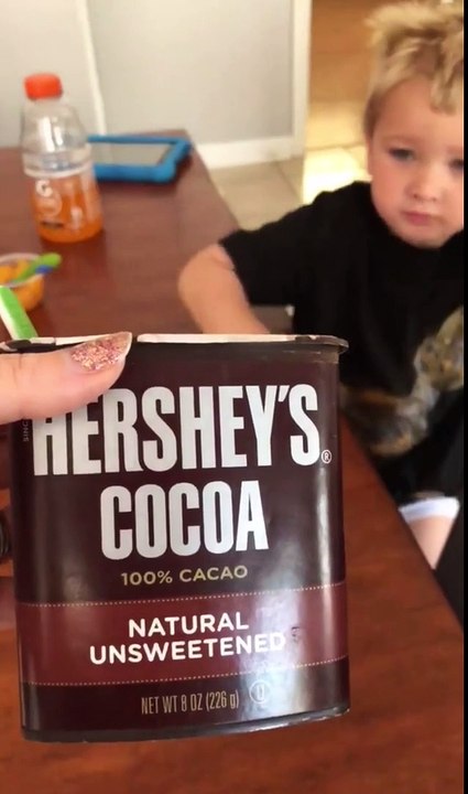 Un enfant goûte du cacao en poudre 100%