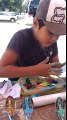 Kaşık ve Yongalar Üzerine Resimler Yapan Sokak Sanatçısı Çocuk