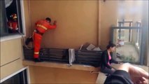 China : bomberos rescatan a mujer en lo alto de edificio