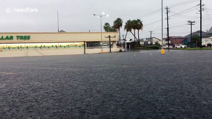 Heavy downpour floods parking lot in Galveston, Texas