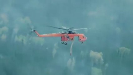 Un hélicoptère bombardier d'eau fait un largage de précision