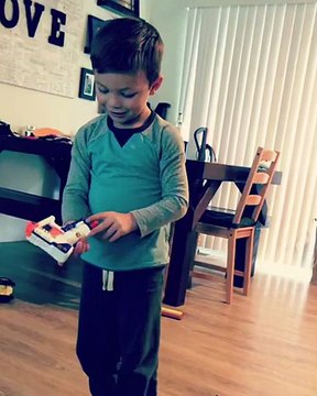 Un enfant teste un pistolet Nerf entre ses jambes