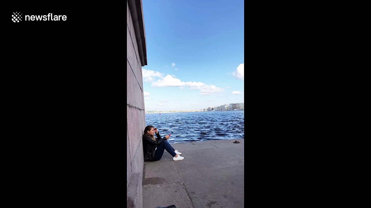 Russian rolls up wall next to girl in St. Petersburg